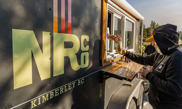 Person buying coffee at concession trailer. Northstar logo on side of vehicle. 