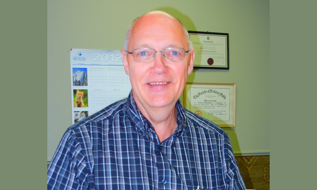 A balding man with glasses in an office