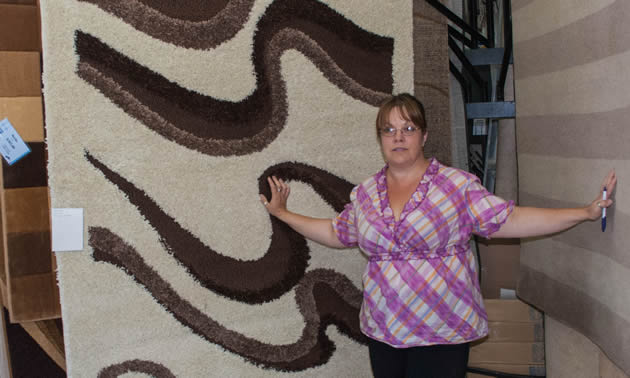 Tracy Wastrodowski standing by some flooring at Nufloors in Creston BC