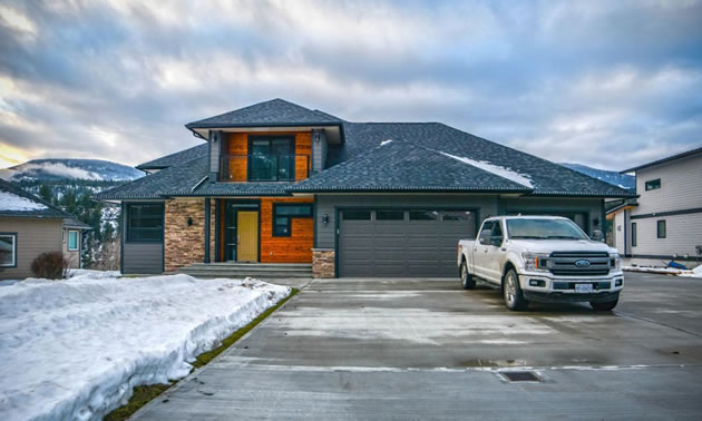 Modern-style house with truck parked in front. 