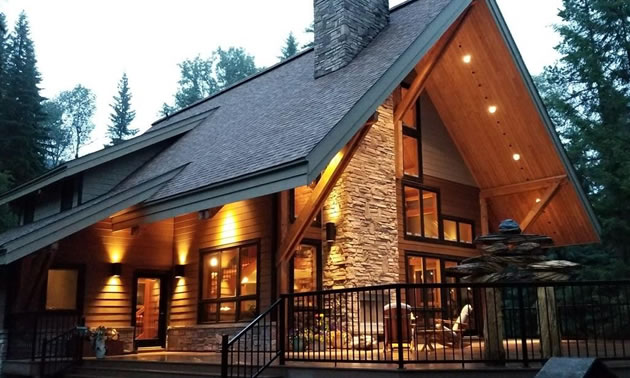 View of large log house with peaked roof. 