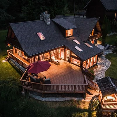 Aerial view of large home lit up at night. 