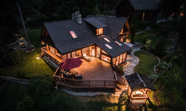 Aerial view of large home lit up at night. 