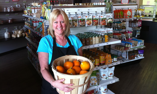 Photo of woman holding large basket of fruit