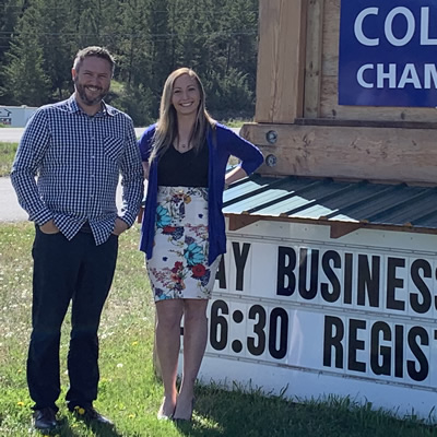 Executive director Pete Bourke and visitor centre supervisor Sarah Miller of the Columbia Valley Chamber of Commerce, beside the chamber sign on Highway 93/95 