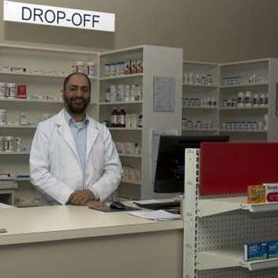 Ahmed Elmaddah standing behind pharmacy counter. 