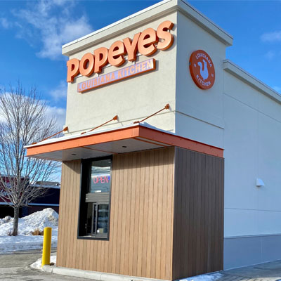 Outside of Popeye's Chicken franchise in Cranbrook showing drive-thru window and side of building. 