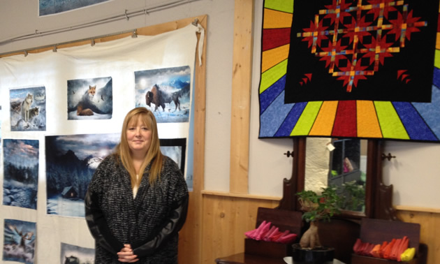 Denise Nagai is standing in front of fabric panels of wild animals.