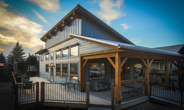 Outside of Radium Brewing, timber-framed building painted grey, sloped roof. 