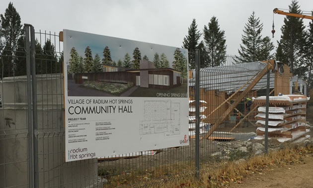 Sign on fence about the new Radium Community Hall. 