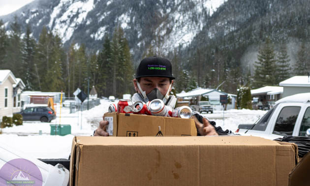 Chandler Lang holding a box of recycling. 