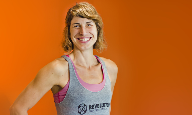 Stephanie China stands against an orange background in her instructor photo for Revelution in Revelstoke, B.C.