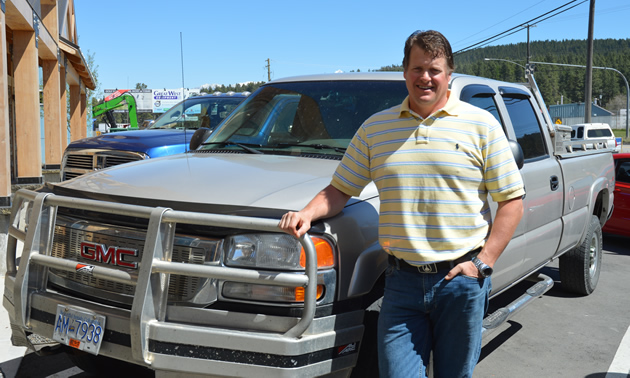 Tall man with GMC pickup truck