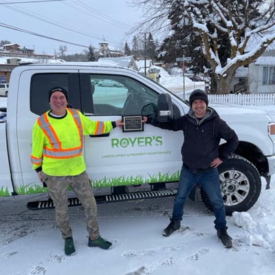 Two men standing beside Royer Landscaping truck. 