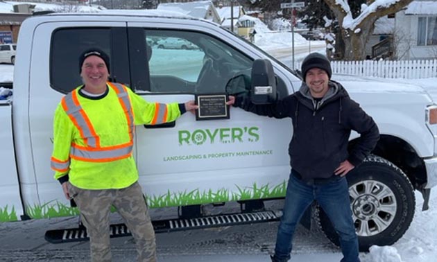 Two men standing beside Royer Landscaping truck. 