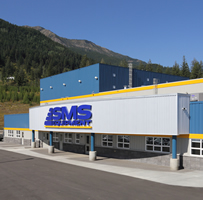 The off-white and blue front of a large corrugated building reads SMS Equipment with the company's logo.