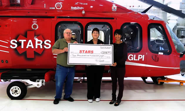 Duane and Linda Pilson present STARS foundation executive, Nafisa Taimuri with a cheque for over $2100