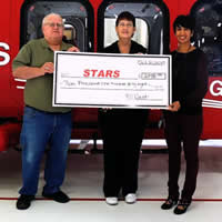 Duane and Linda Pilson present STARS foundation executive, Nafisa Taimuri with a cheque for over $2100