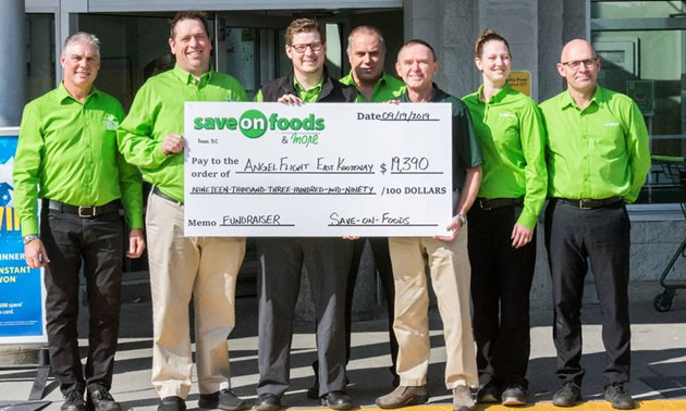 Save-On-Foods managers with large cheque showing total of fundraising efforts. 