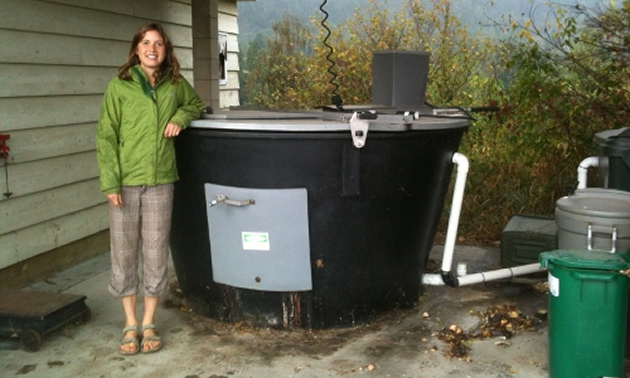 Selkirk student, Cali Olleck, stands next to one of the college's large composters.