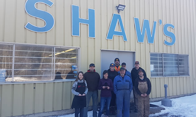 Staff are standing outside their workplace, with Shaw's in big blue letters on the building. Shaw’s Enterprises won the Industrial Business Award.