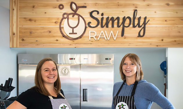 Ali Hadikin (L) and Melanie Joy standing in front of Simply Raw counter. 