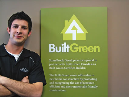 Young man stands beside Built Green sign