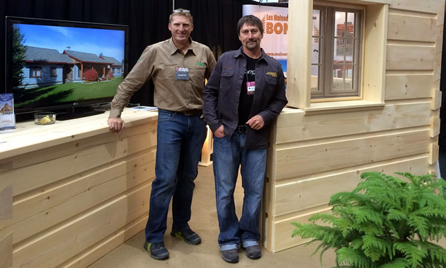 Max Fanderl and Aaron Cameron stand in front of a display wall.