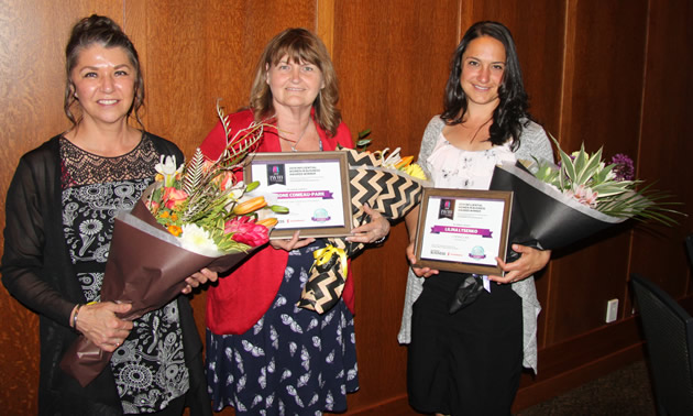 Three smiling business-women holding bouquets of flowers: Tammy Verigin-Burk, Castlegar & District Chamber of Commerce, guest speaker; Simone Comeau-Park, L'Bear's Natural Foods & Supplements, Trail; and Lilina Lysenko, Lysenko Law, Rossland. Not pictured: Judy Banfield, Mountain Baby, Nelson.