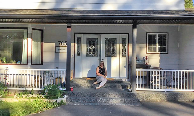 Kim sitting outside of house on porch. 