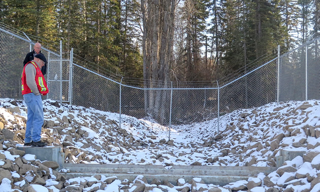 RDEK Engineering Technician shows Electoral Area B Director Stan Doehle the new weir that has been installed as part of the Tie Lake Dam project.