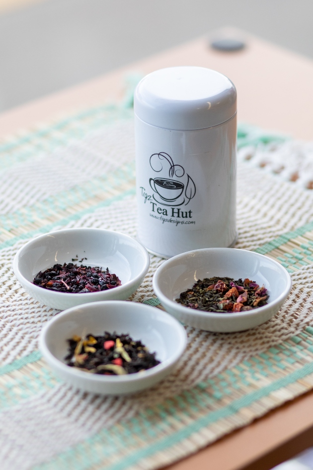 three white tea cups and a tall white tea container