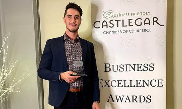 Solomon Burk, owner of Train with Sully, standing and holding his award. 