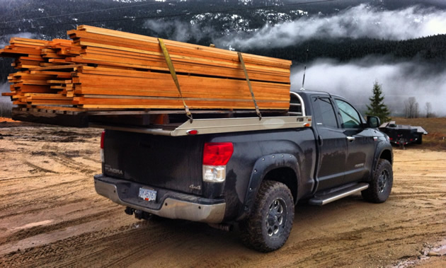 A black truck is loaded with Douglas fir.