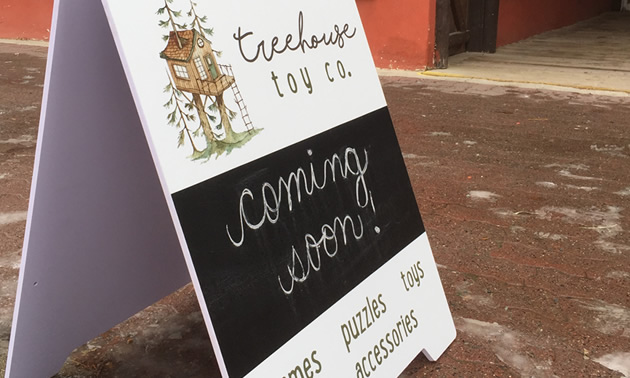 Sandwich board advertising the Treehouse Toy Co. 