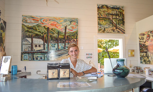 Smiling young man behind counter. 