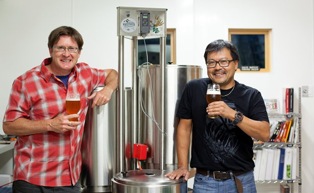 Kenton Donaldson and Mark Nagao standing in front of brewing equipment.