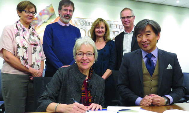 Dr. Catherine Mateer (UVic) and Dr. Stan Chung (College of the Rockies) sign two new partnership agreements as (L-R) deans of instruction Heather Hepworth and Darrell Bethune, director of student affairs Doris Silva and dean of instruction Jack Moes look on.