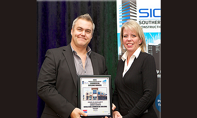 Steve Smith, marketing manager at Vic Van Isle Construction accepts award from Fortis BC representative Shelly Thomson