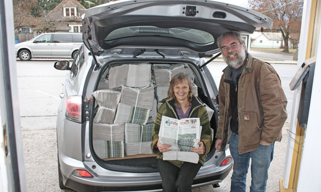 The owners of The Valley Voice, Jan McMurray and Dan Nicholson which bundles of newspapers. 
