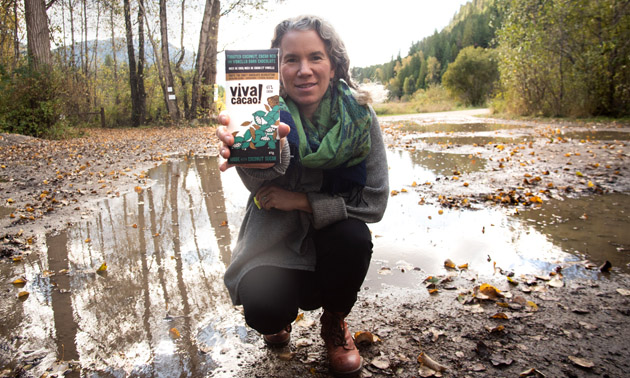 Beth Campbell, owner of Viva Cacao, holding up a bar of her chocolate. 