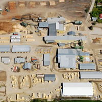 Aerial view of a large lumber yard, including industrial buildings