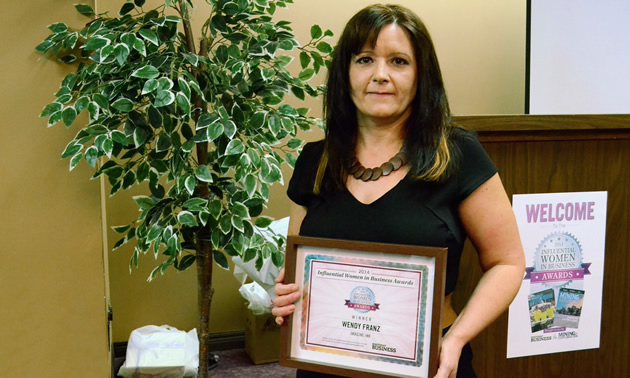 Wendy Franz of Imagine Ink and I Love Creston holds her Influential Women in Business Award certificate.