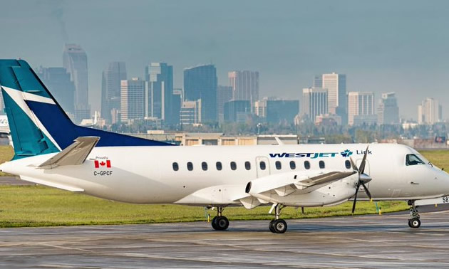 A WestJet plane sitting on the tarmac. 