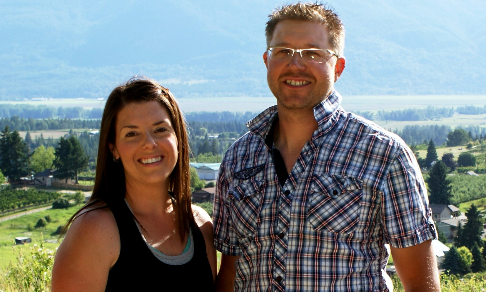 Amy White and David Mutch stand at the top of a hill overlooking their orchard at JRD Farms.