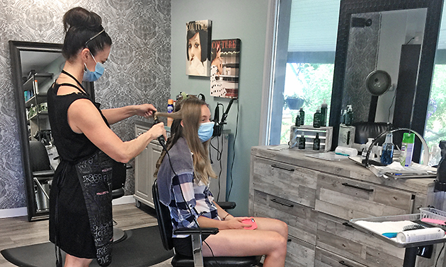 Hairstylist Kellie Wolf styling a client's hair. 