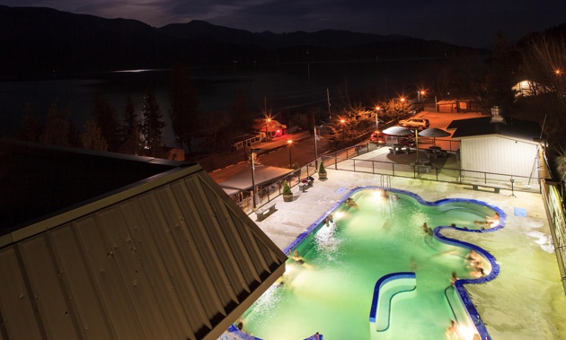 Pool at Ainsworth Hot Springs Resort and Kootenay Lake at night.