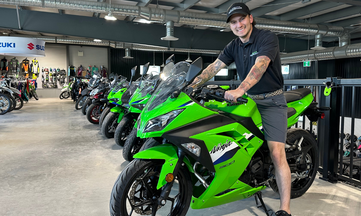 Dayton Pouliot on a green street bike in the showroom