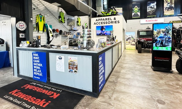 The front desk at the All Seasons showroom, with ATVS, apparel and other merchandise