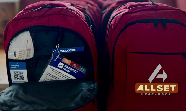 Two burgundy evac packs stuffed with emergency gear